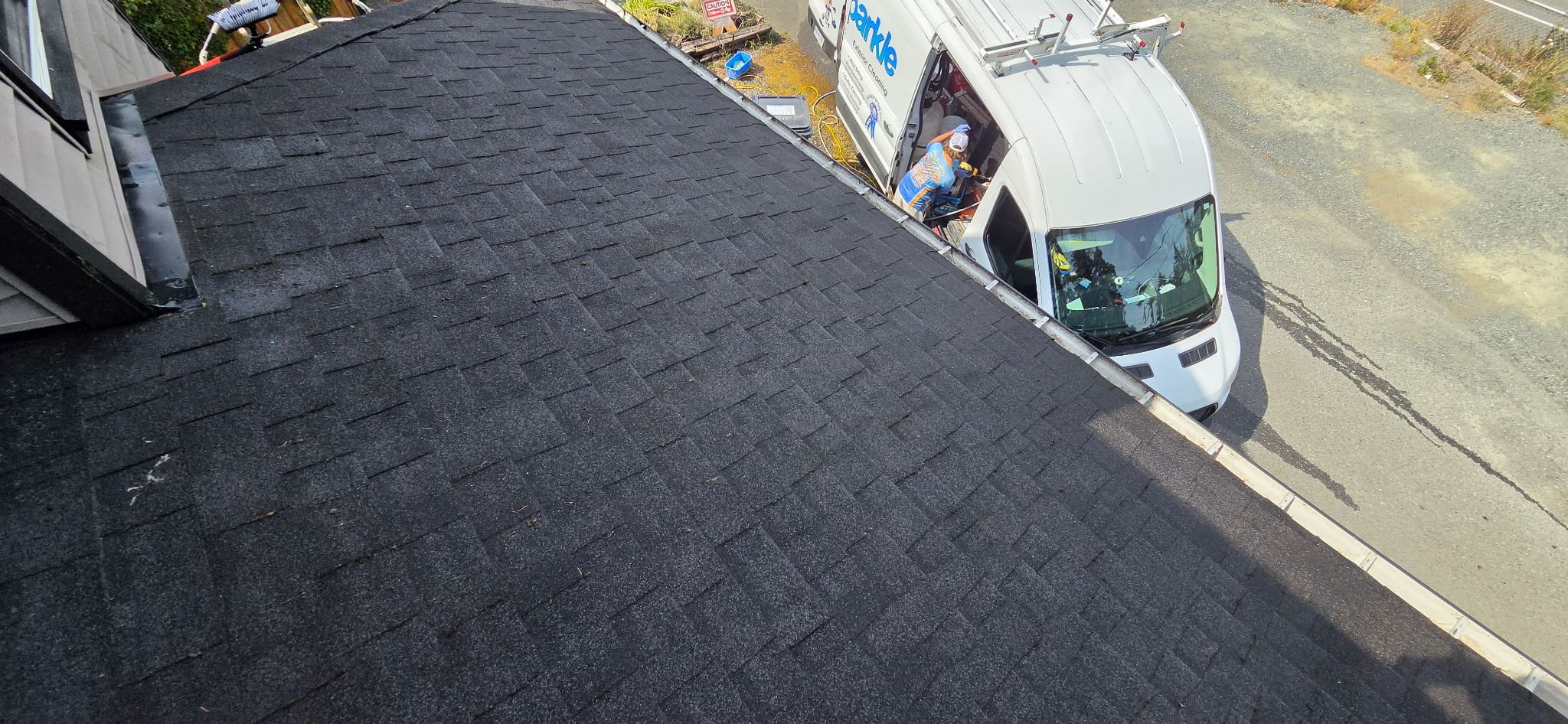 A Nanaimo home's roof freshly demossed with Mr. Sparkle's truck and crew visible in the driveway.